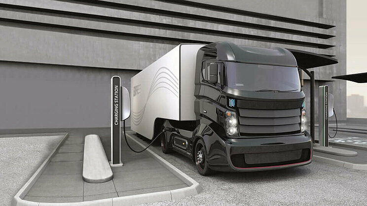 Ein grauer LKW mit alternativen Antrieb an einer Ladestation.