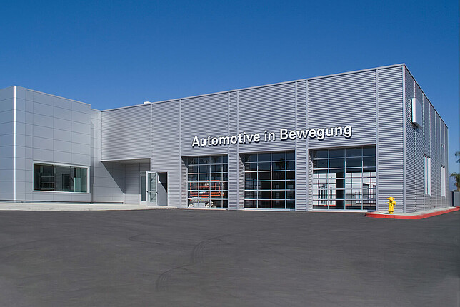 Autohaus Landeslotsenstelle Transformationswissen BW Autohaus mit silberner Außenfassade und Schriftzug "Automotive in Bewegung"