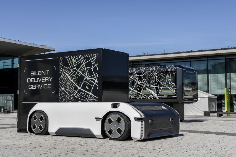 U-Shift mit Cargokapsel Das Foto zeigt ein autonomes, fahrerloses, elektrisches Fahrzeugkonzept U-Shift vor einem Gebäude.